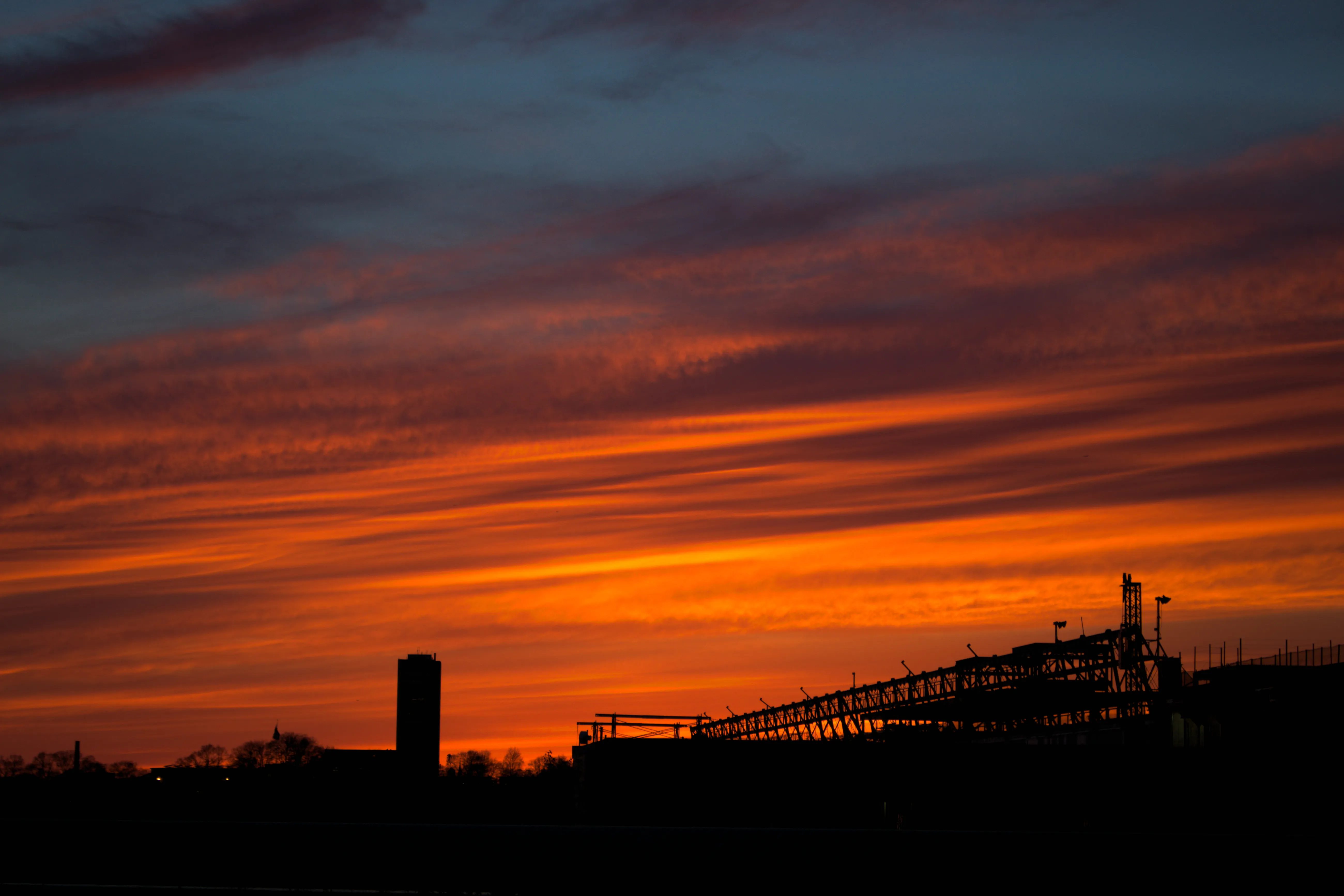 A sunset with some industrial buildings in the foreground